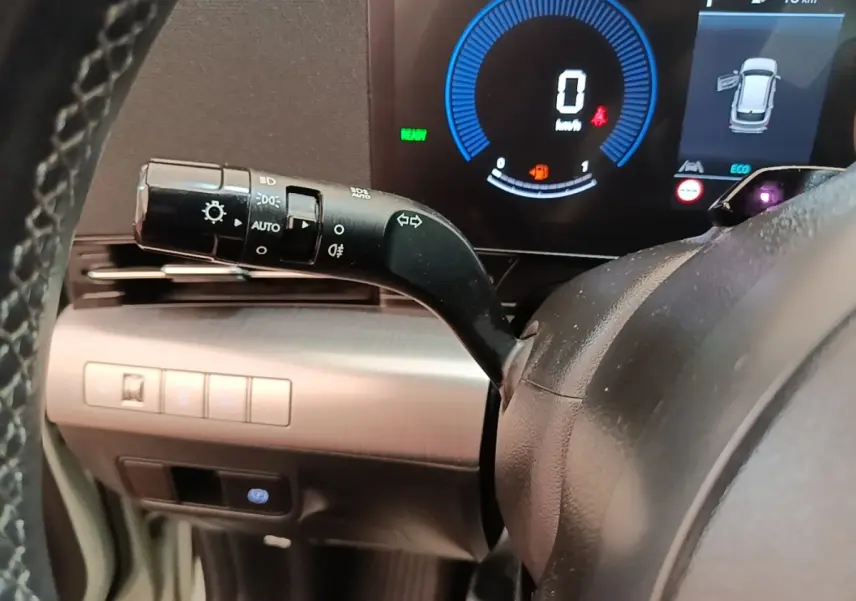 Gros plan sur la manette de clignotants et tableau de bord numérique du Hyundai Kona 1.6 Hybrid 2024, intérieur noir.