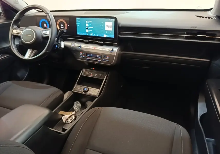 Intérieur avant du Hyundai Kona 2024, vue côté conducteur, tableau de bord noir avec écran tactile 12,3 pouces.