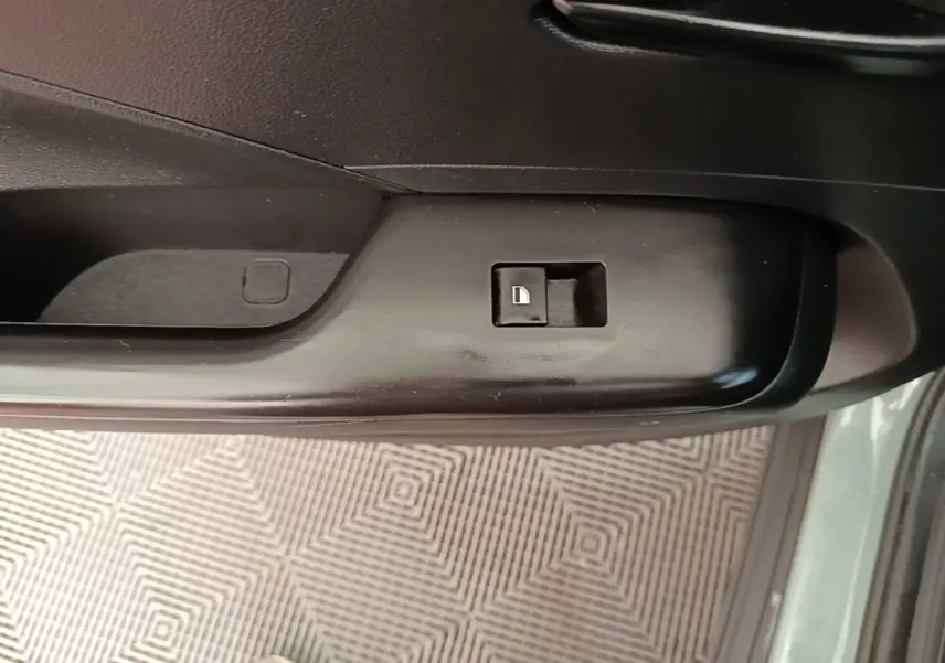 Gros plan sur le bouton de verrouillage de porte côté conducteur d’un Hyundai Kona vert 2024, intérieur noir.
