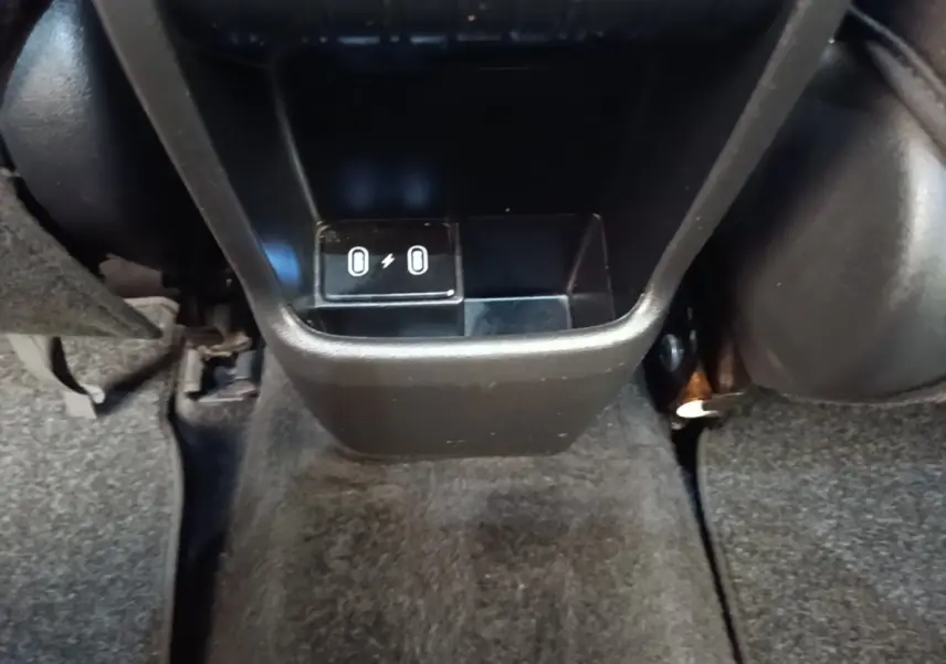 Gros plan sur la console centrale arrière noire du Hyundai Kona 1.6 Hybrid 2024 avec ports USB visibles.