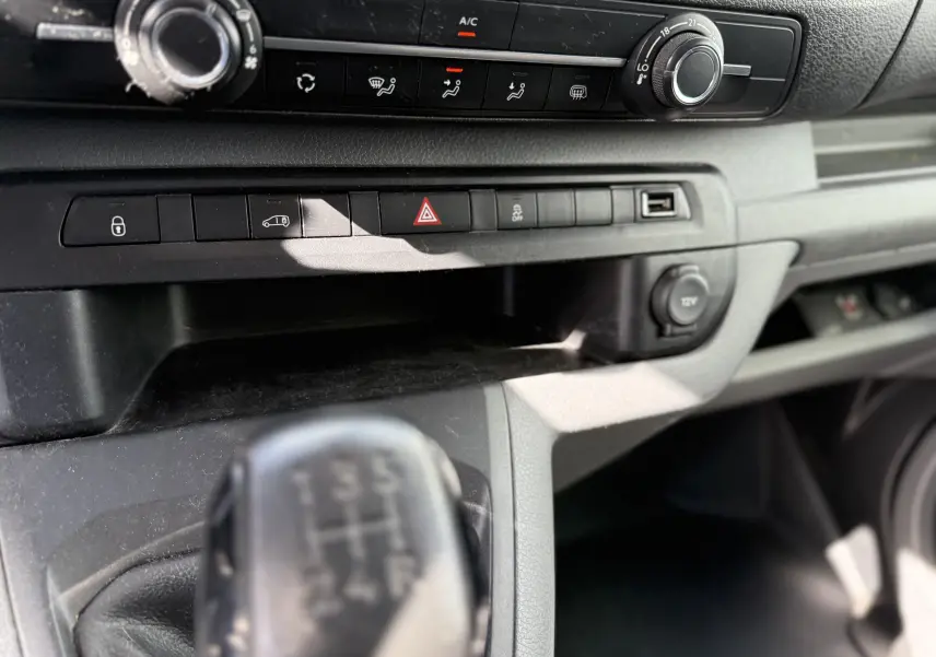 Gros plan sur la console centrale du Peugeot Expert FGN 2017, montrant la boîte manuelle et les commandes de climatisation.