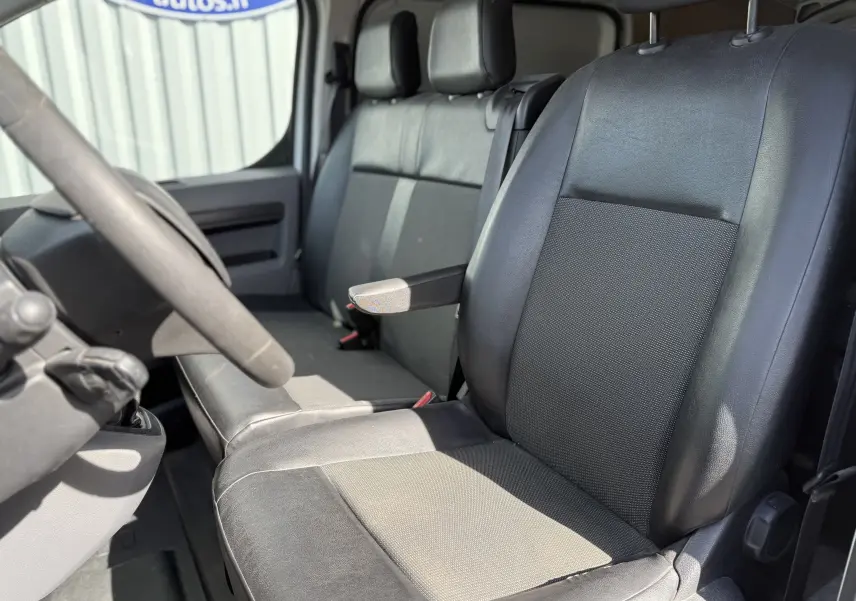 Vue intérieure côté conducteur du Peugeot Expert FGN 2017, sièges tissu noir avec accoudoir central.