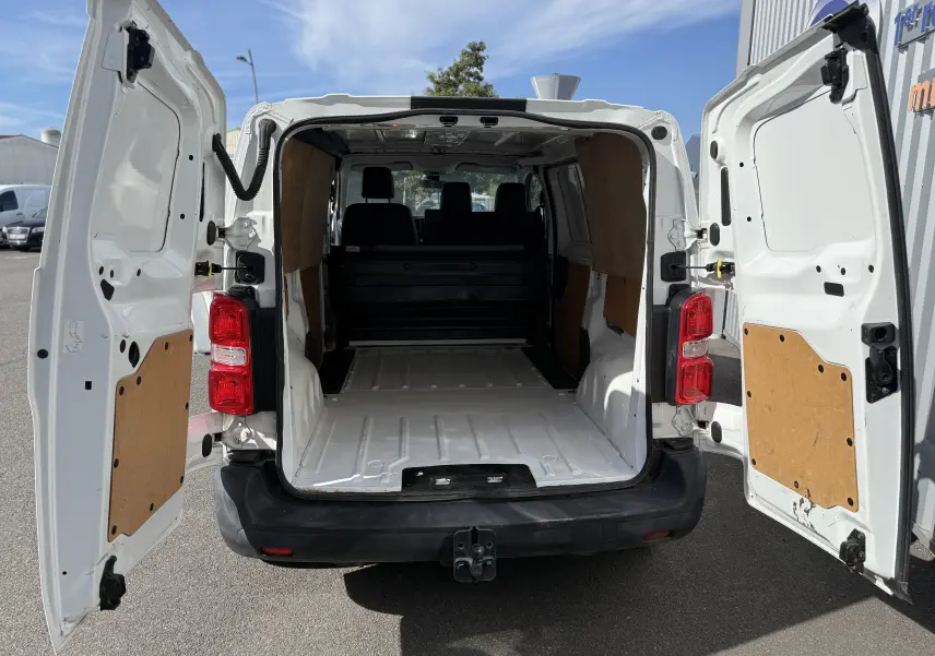 Vue arrière du Peugeot Expert FGN blanc 2017 avec portes ouvertes montrant l'espace de chargement vide et les panneaux en bois.