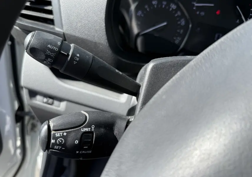 Gros plan sur les commandes au volant du Peugeot Expert FGN blanc 2017, montrant les leviers de clignotants et régulateur de vitesse.