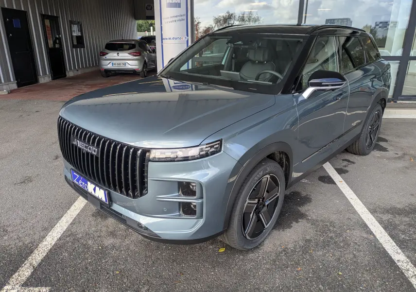 Vue 3/4 avant droite du JAECOO J7 hybride rechargeable en olive grey metal avec toit noir et calandre verticale noire.