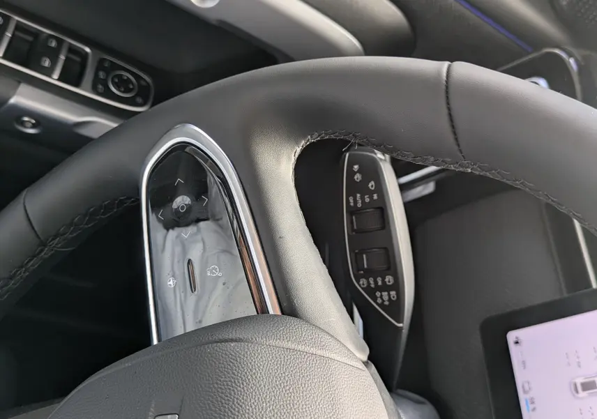 Vue rapprochée du volant en cuir noir du JAECOO J7 1.5 TGDI PHEV 279CH EXCLUSIVE avec commandes intégrées et tableau de bord partiel.