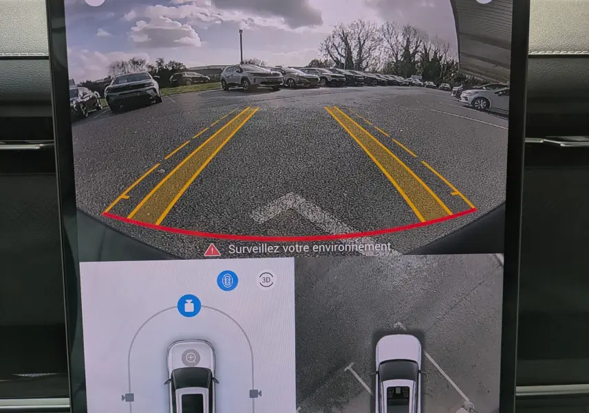 Écran intérieur montrant la caméra de recul et vue 360° du JAECOO J7 olive gris métal avec toit noir en stationnement.