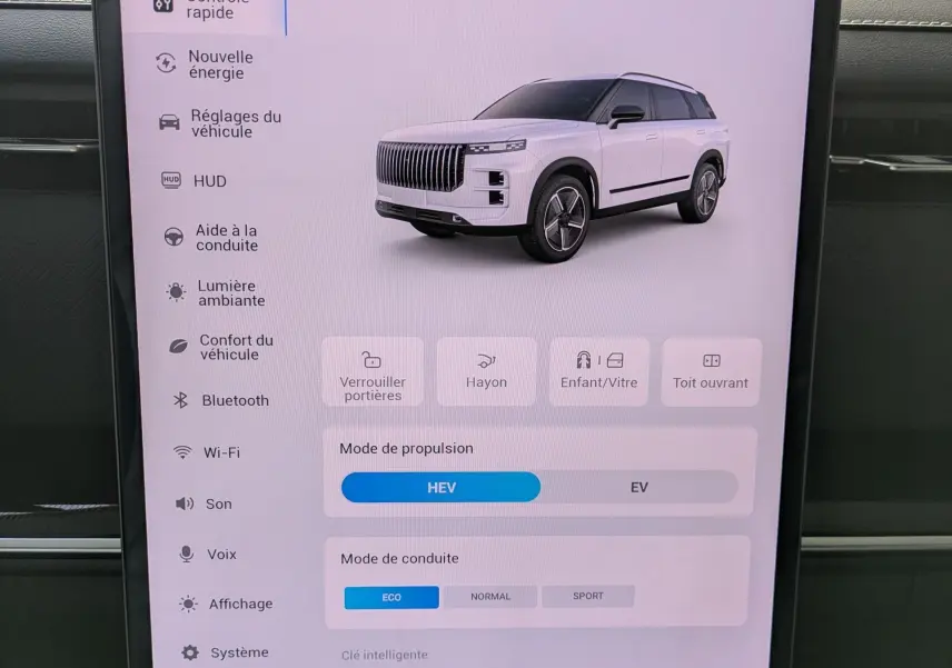 Écran tactile intérieur montrant les réglages du véhicule avec une image 3D du SUV JAECOO J7 en blanc, vue 3/4 avant.