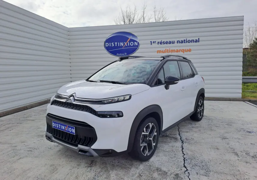 Citroën C3 Aircross blanc banquise en 3/4 avant droit avec toit noir et jantes alliage distinctives.