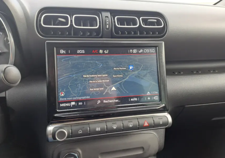 Vue rapprochée de l'écran tactile central du tableau de bord noir du Citroën C3 Aircross blanc banquise 2024 avec navigation affichée.