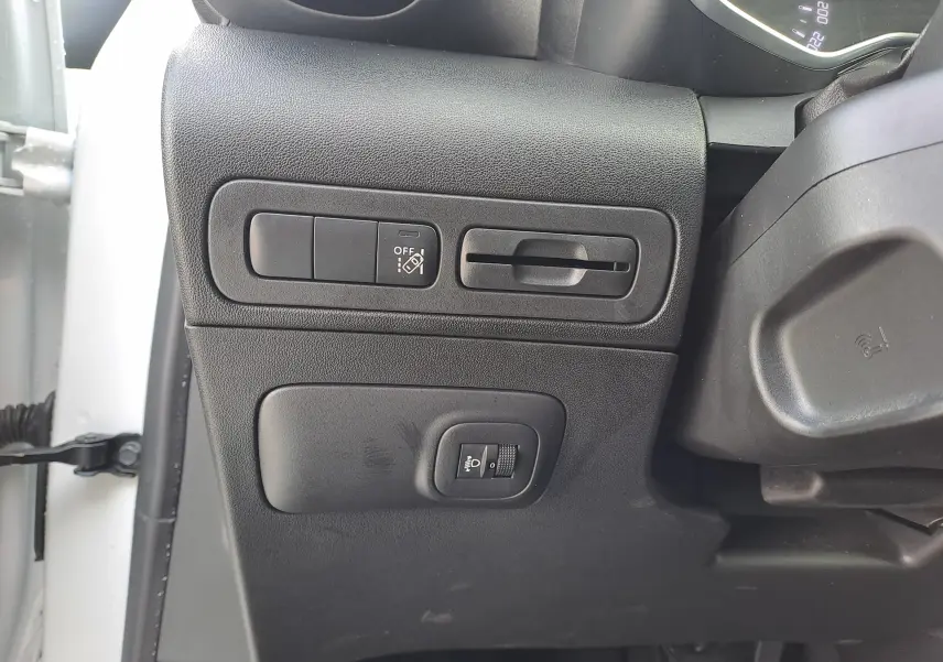 Vue rapprochée des commandes de réglage d'éclairage et d'assistance sur le côté gauche du tableau de bord d'une Citroën C3 Aircross blanc banquise 2024.