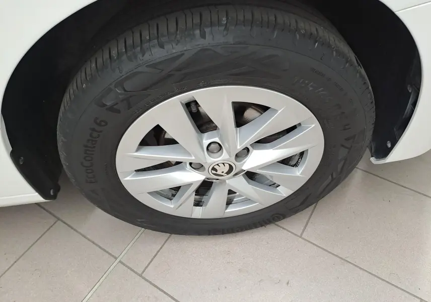 Gros plan sur la roue avant gauche d'une Skoda Fabia blanc candy 2023 avec jante alliage et pneu Continental EcoContact 6.