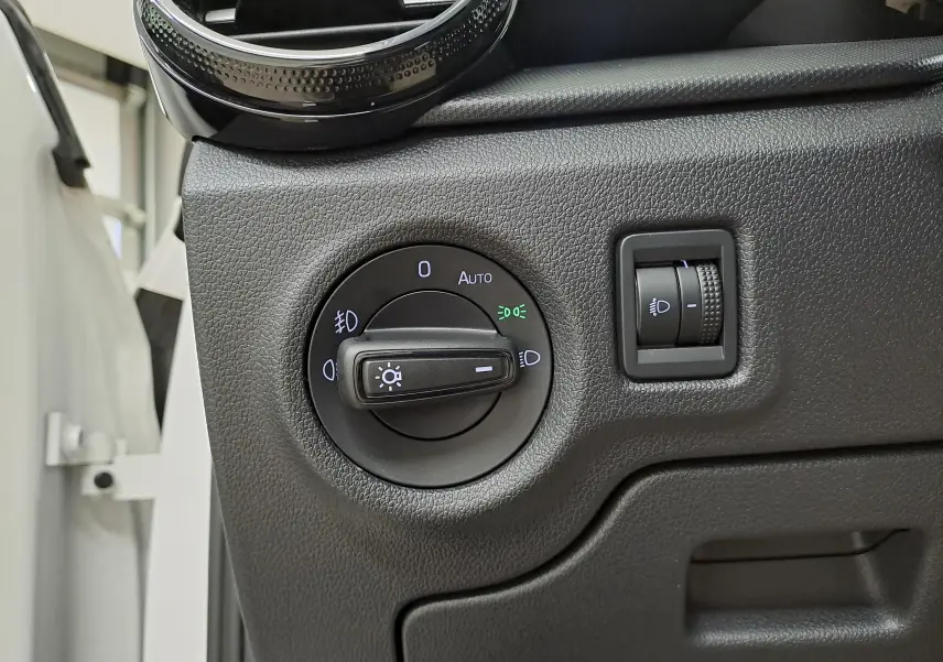 Gros plan sur les commandes d'éclairage du tableau de bord d'une Skoda Fabia 2023 blanc candy, version Ambition.