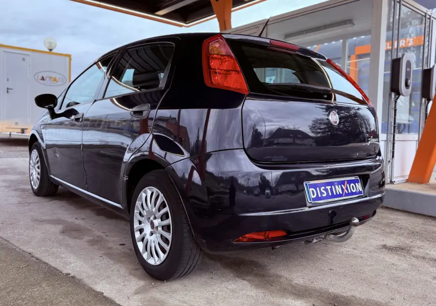 Vue 3/4 arrière droite d'une Fiat Punto noire de 2009 avec attelage et jantes multibranches.