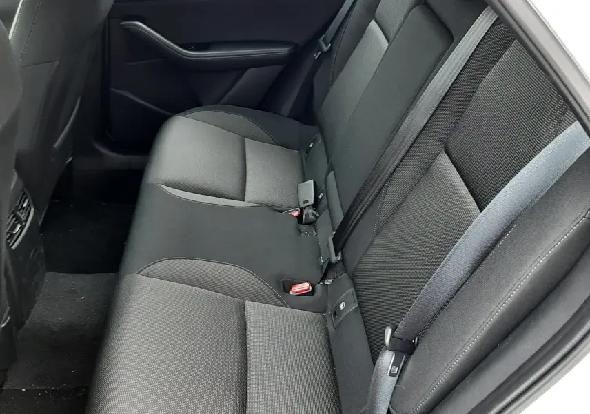 Vue intérieure côté droit des sièges arrière noirs en tissu du Mazda CX-30 2024 couleur blanc céramique.