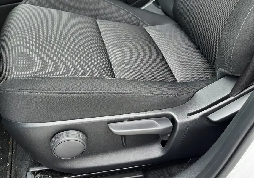 Gros plan sur le siège avant conducteur en tissu noir du Mazda CX-30 2024, avec réglages manuels visibles.