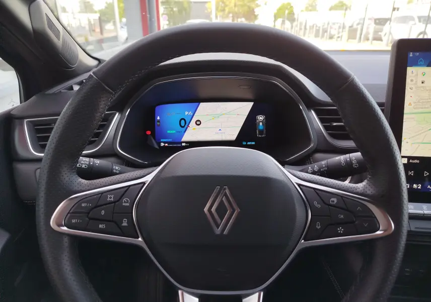 Vue intérieure centrée sur le volant et le tableau de bord numérique du Renault Symbioz 2025, détails de commandes visibles.