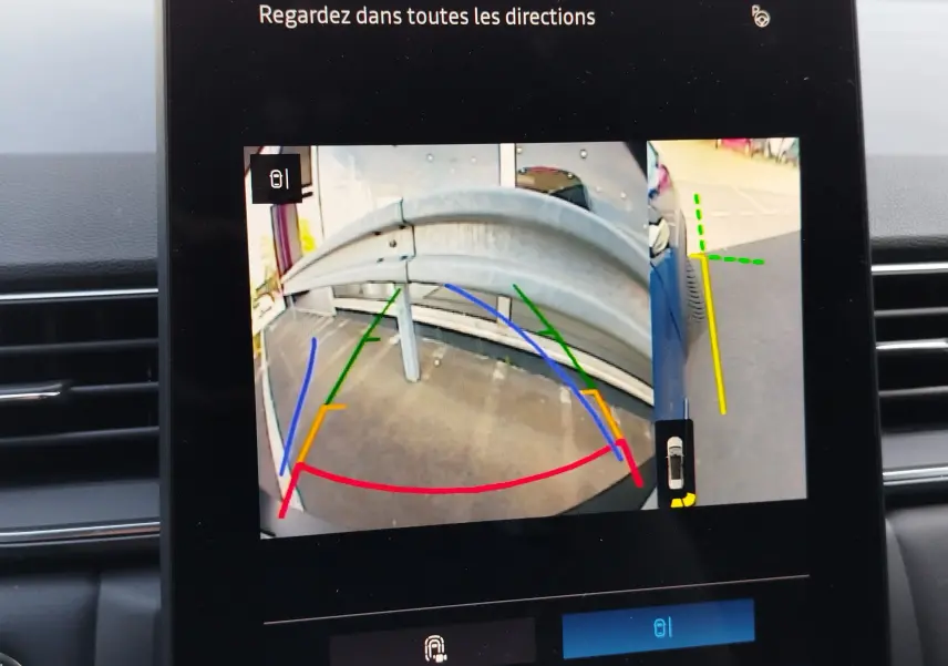 Vue écran caméra de recul du Renault Symbioz bleu iron metal, montrant un garde-corps métallique et les lignes d’aide au stationnement.