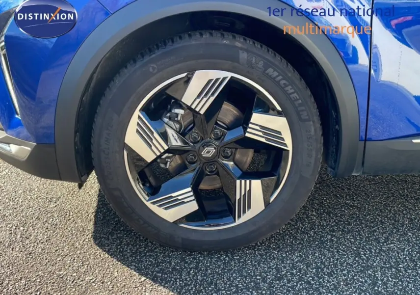 Gros plan sur la roue avant droite du Renault Symbioz bleu iron metal, mettant en valeur la jante bi-ton stylisée.