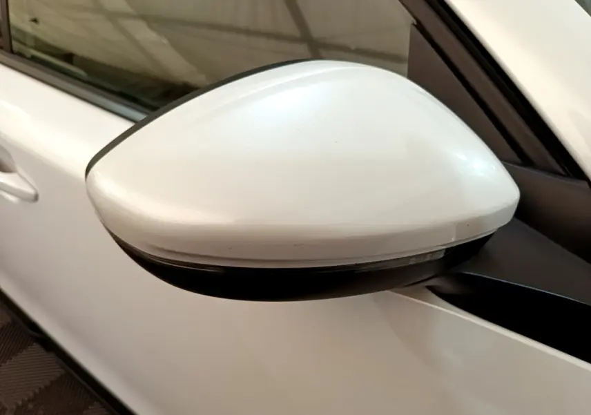 Gros plan sur le rétroviseur droit blanc d'un Peugeot 2008 1.5 BlueHDi 2021, avec clignotant intégré.