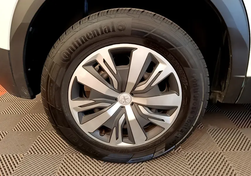 Gros plan sur la roue avant droite d’un Peugeot 2008 blanc, avec jante alliage et pneu Continental visible.