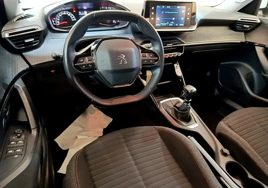 Vue intérieure avant du Peugeot 2008 1.5 BlueHDi 2021, volant cuir, écran tactile et boîte manuelle visibles.