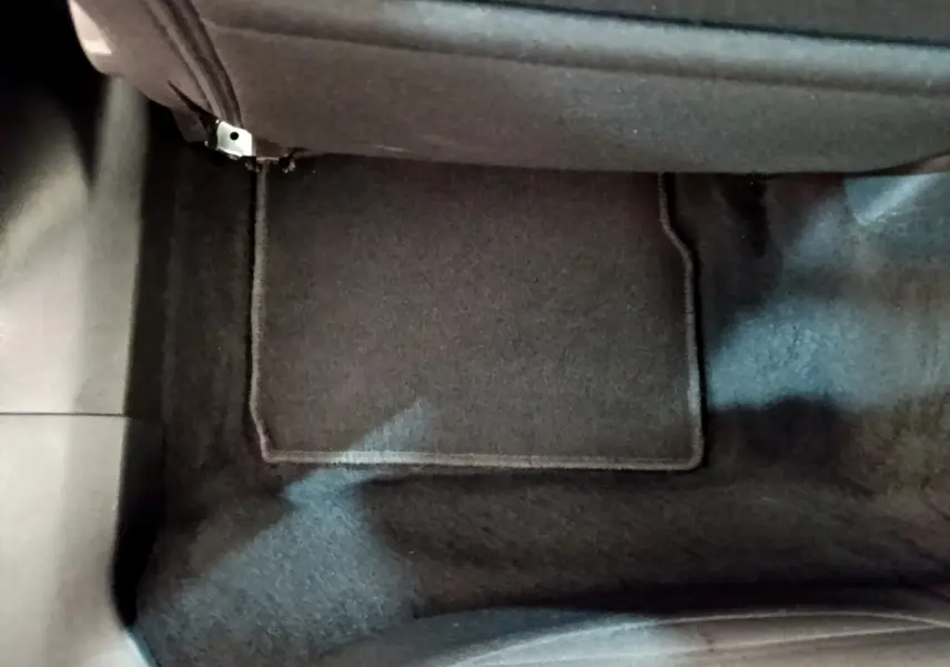 Vue rapprochée du tapis de sol noir côté passager avant du Peugeot 2008 blanc de 2021.