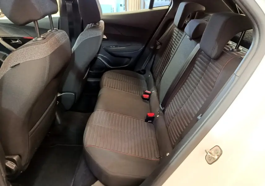 Vue intérieure côté droit montrant la banquette arrière noire avec surpiqûres rouges du Peugeot 2008 blanc de 2021.