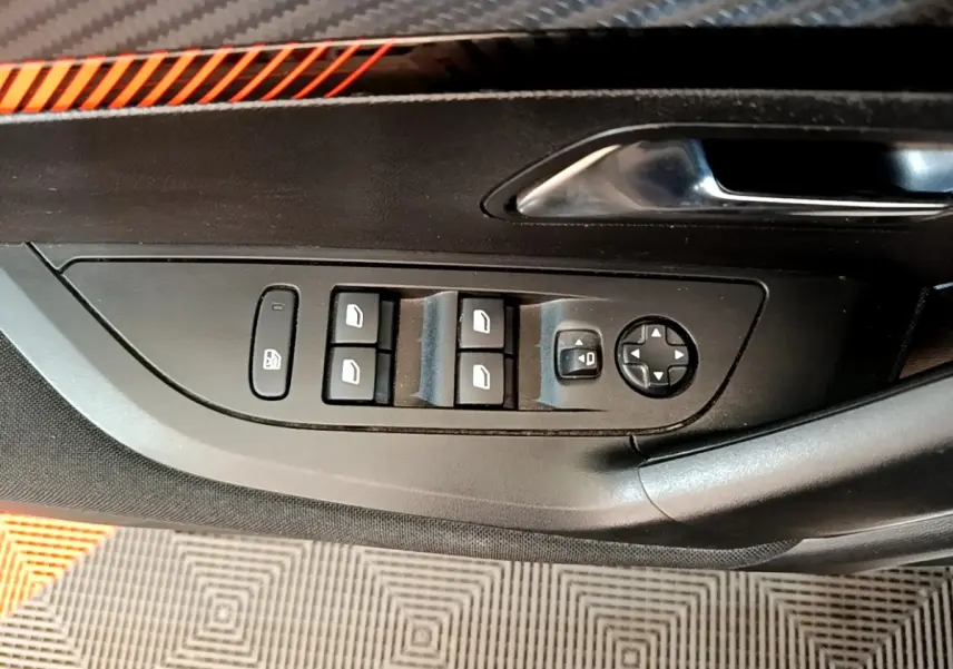Vue rapprochée des commandes des vitres et rétroviseurs sur la portière côté conducteur d’un Peugeot 2008 blanc.