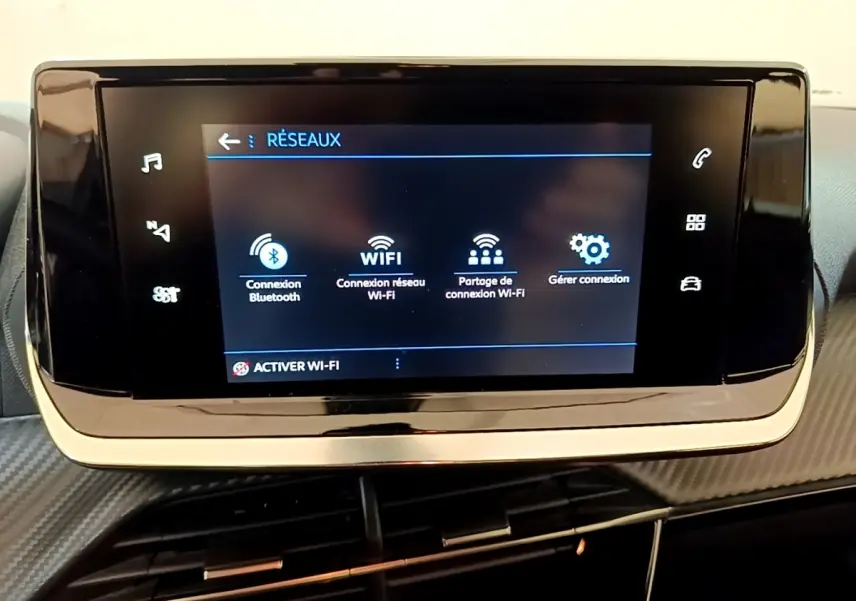Écran tactile central de la Peugeot 2008 blanc, affichant les options de connexion Wi-Fi et Bluetooth.