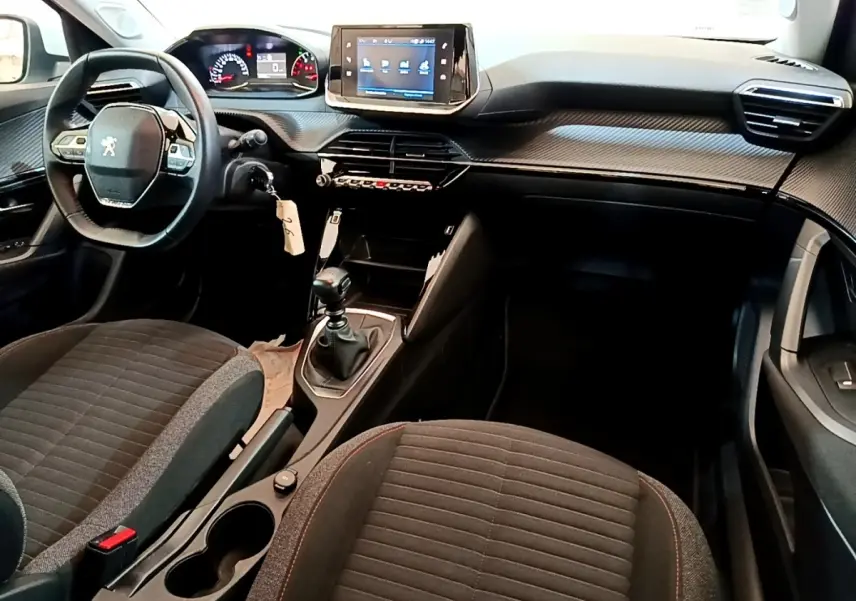 Intérieur de la Peugeot 2008 1.5 BlueHDi 2021, vue côté conducteur, tableau de bord avec écran tactile et volant cuir.