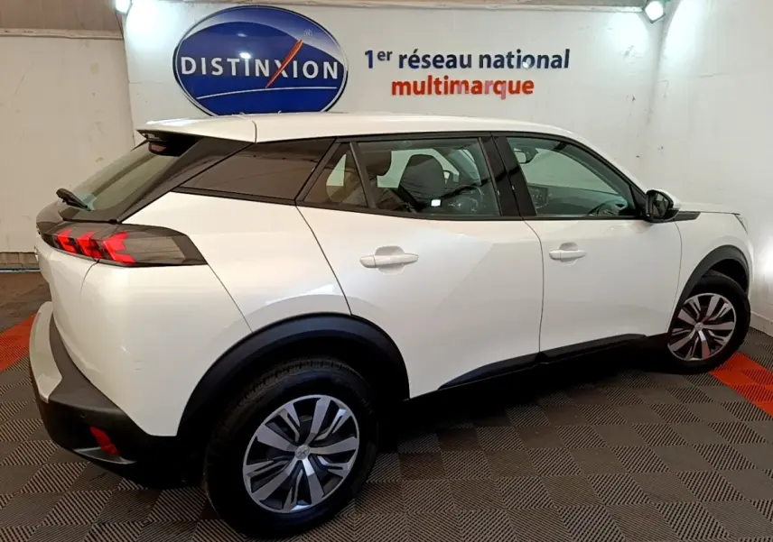 Peugeot 2008 blanc vue de profil côté droit, avec toit noir et feux arrière LED distinctifs.
