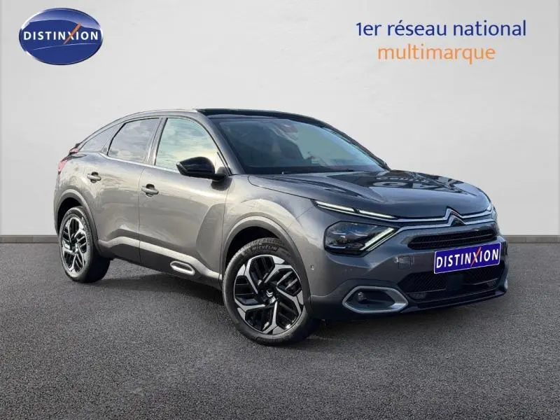 Citroën C4 gris 2024 en 3/4 avant droit, avec jantes noires et détails modernes sur la calandre et les phares.