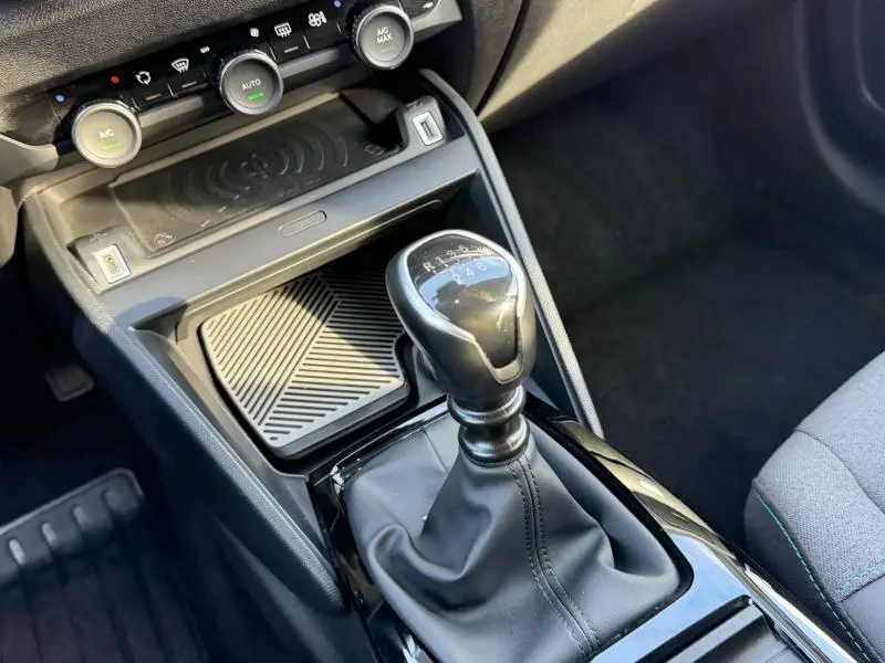 Gros plan sur la console centrale grise de la Citroën C4 2024, mettant en valeur le levier de vitesse manuel et les commandes de climatisation.