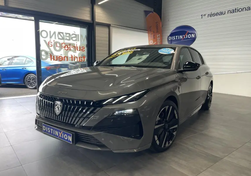 PEUGEOT 308 gris sélénium vue 3/4 avant en intérieur, calandre noire brillante et jantes alliage bi-ton.
