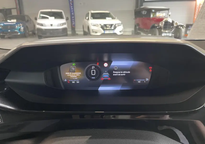 Vue du combiné numérique de la Peugeot 308 gris sélénium, affichant le mode parking et alertes sur fond noir.