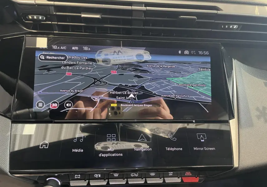 Vue rapprochée de l’écran tactile central du Peugeot 308 gris Selenium avec navigation 3D et commandes tactiles.