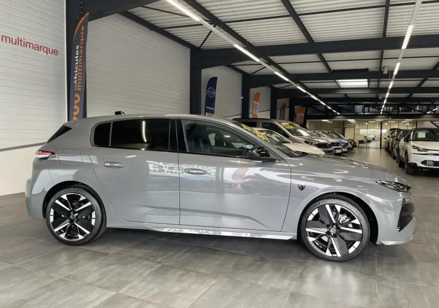 Peugeot 308 gris selenium vue de profil côté gauche en intérieur avec jantes alliage bi-tons et vitres teintées.