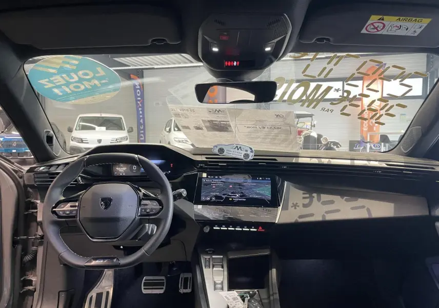 Vue intérieure avant de la Peugeot 308 gris selenium, avec volant compact GT, écran tactile et tableau de bord numérique.
