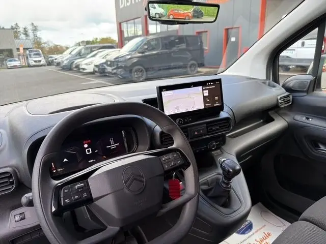 Vue intérieure du tableau de bord du Citroën Berlingo blanc 2025, avec volant multifonctions et écran tactile central.