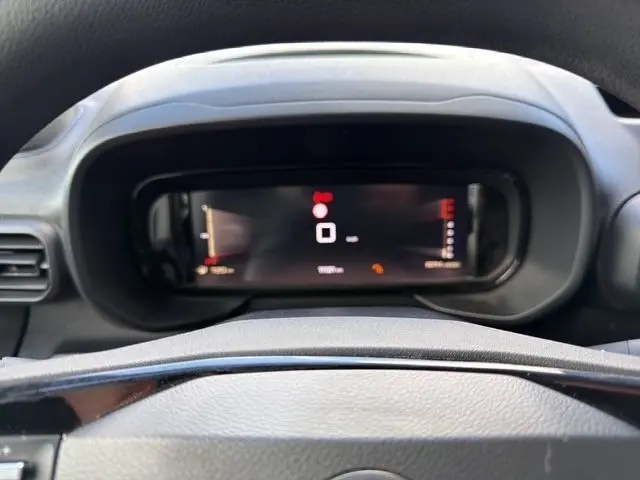 Vue rapprochée du combiné d'instruments numérique noir du tableau de bord du Citroën Berlingo blanc 2025.