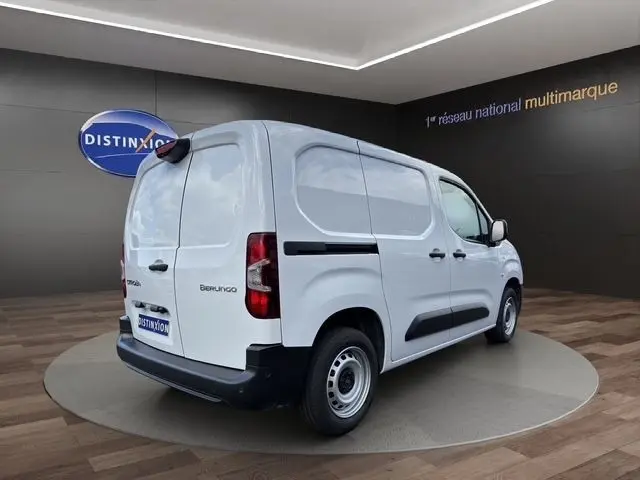 Vue 3/4 arrière droite d'un utilitaire Citroën Berlingo blanc, avec portes arrière pleines et protections latérales noires.