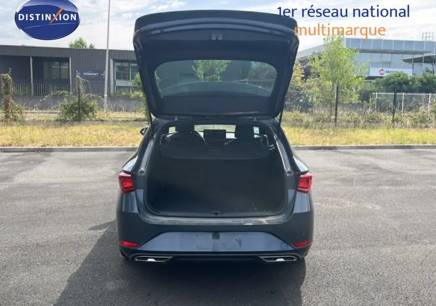 Vue arrière d'une SEAT LEON ST 1.5 eTSI 150CH FR Special Edition gris magnétique avec coffre ouvert sur parking.