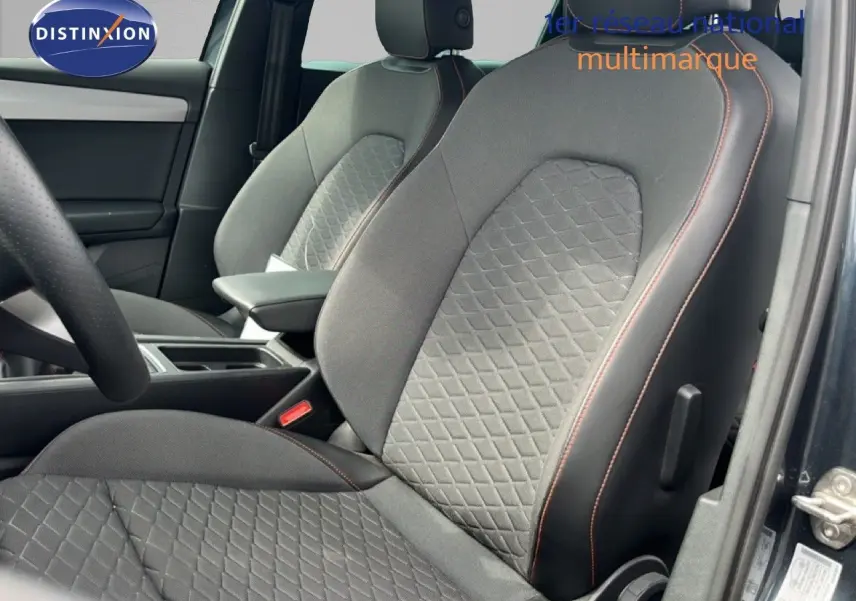 Vue intérieure côté conducteur du siège avant gris noir avec surpiqûres orange du SEAT LEON ST 1.5 eTSI 2025.