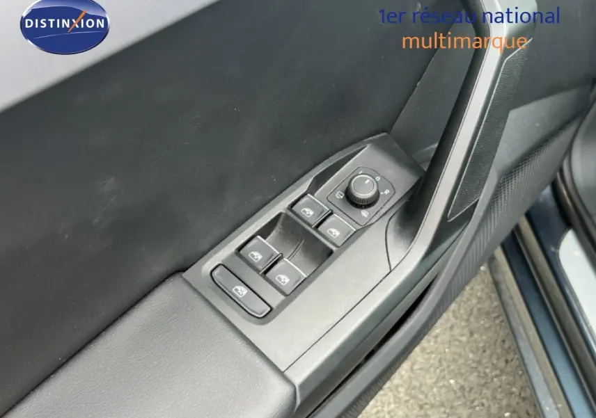 Gros plan sur la commande des vitres électriques côté conducteur d'une SEAT LEON ST gris magnétique 2025.