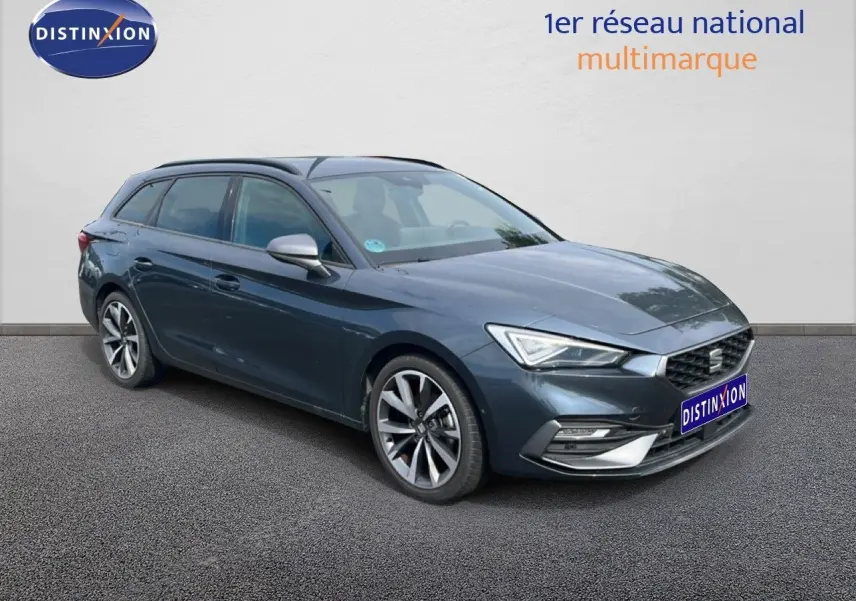 SEAT Leon ST gris magnétique métal vue 3/4 avant droit, avec jantes alliage et calandre hexagonale distinctive.