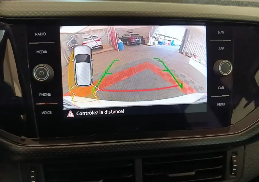 Écran tactile intérieur montrant la caméra de recul avec vue arrière et indication de distance de stationnement.