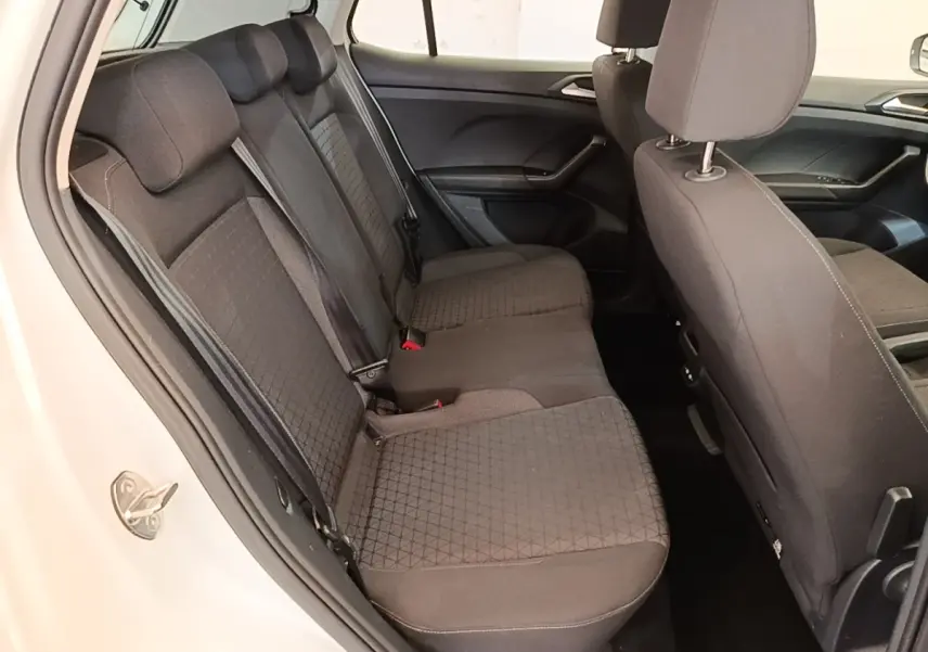 Vue intérieure côté gauche sur la banquette arrière noire du Volkswagen T-Cross blanc, avec détails des sièges et ceintures.