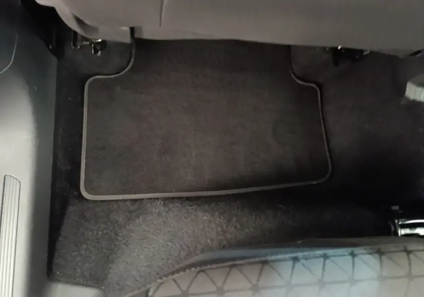 Vue intérieure du tapis de sol noir côté passager avant du Volkswagen T-Cross blanc 2022.