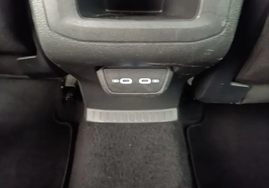 Vue rapprochée des ports USB arrière sur la console centrale noire du Volkswagen T-Cross blanc 2022.